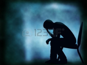 Editable vector silhouette of a man sitting with his head in his hand; background made with a gradient mesh